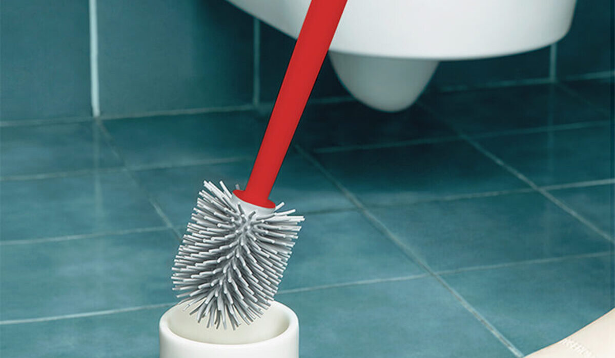 A red handle silicone Toilet Brush with toilet background