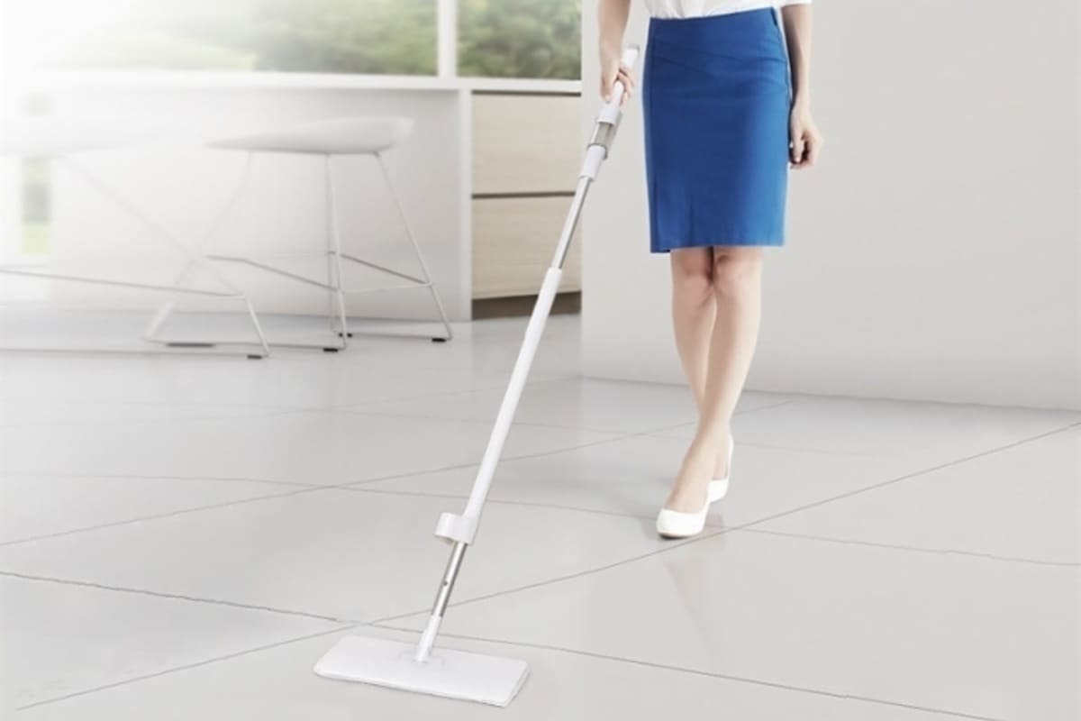 A person uses flat mop to keep the floors clean