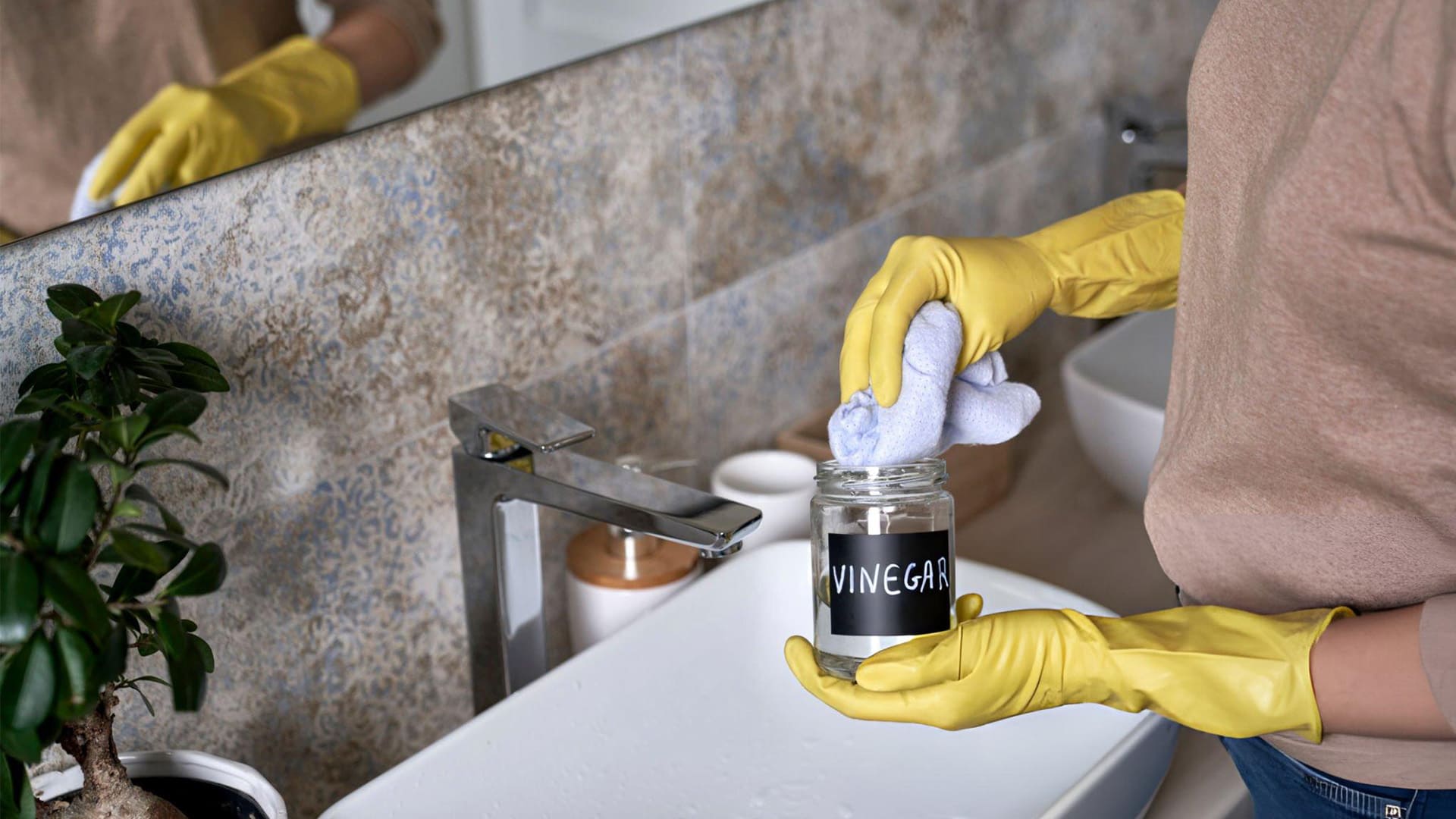 a woman holding a white distilled vinegar preparing to clean bathroom